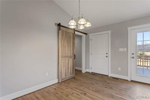 interior space featuring vaulted ceiling, wood-type flooring, and a barn door