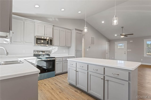 kitchen with pendant lighting, appliances with stainless steel finishes, gray cabinets, and sink