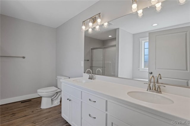 bathroom with a shower with door, vanity, hardwood / wood-style flooring, and toilet