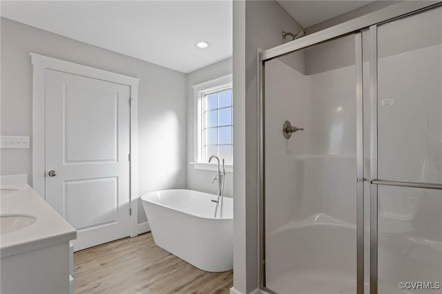 bathroom with vanity, shower with separate bathtub, and hardwood / wood-style floors