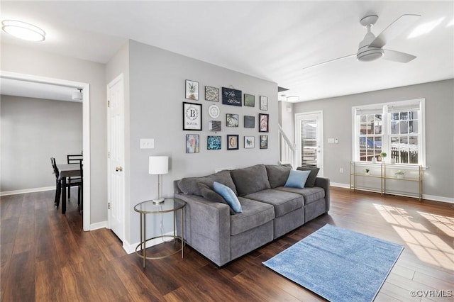 living room featuring dark wood-type flooring and ceiling fan