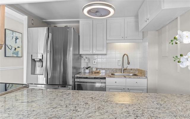 kitchen featuring stainless steel appliances, white cabinetry, decorative backsplash, and sink