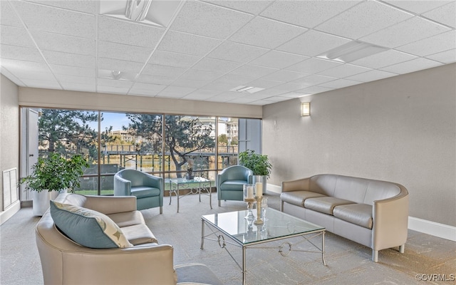 living room with a paneled ceiling and light carpet