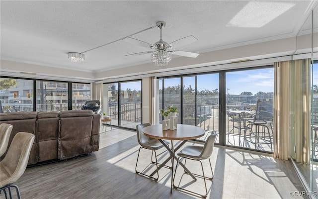 sunroom featuring ceiling fan with notable chandelier