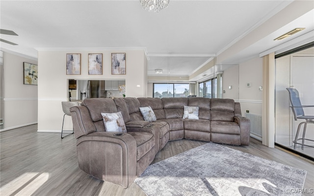 living room with light wood-type flooring and crown molding