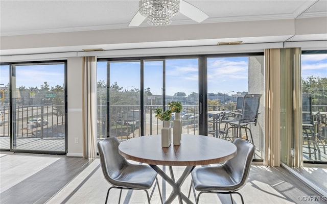 dining space featuring a chandelier, crown molding, wood-type flooring, and plenty of natural light