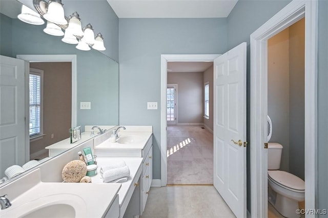 bathroom with vanity, a chandelier, and toilet