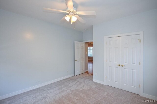 unfurnished bedroom with ceiling fan, a closet, and light carpet