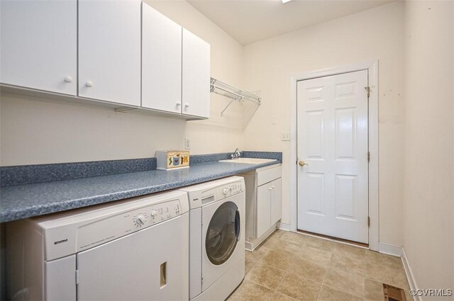 washroom featuring sink, washing machine and clothes dryer, and cabinets