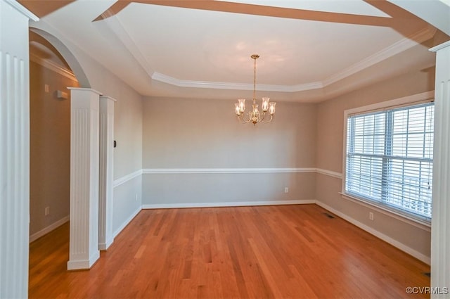 spare room with visible vents, baseboards, light wood finished floors, arched walkways, and a notable chandelier