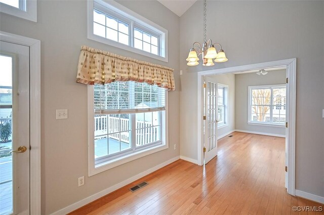 unfurnished dining area featuring hardwood / wood-style flooring and a notable chandelier