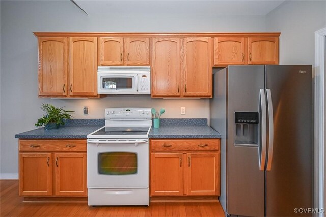 kitchen featuring white appliances and light hardwood / wood-style flooring