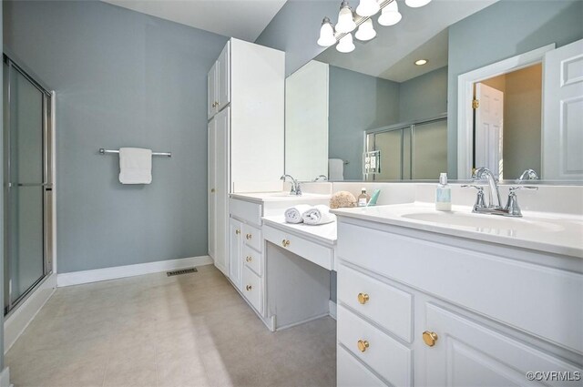 bathroom featuring a shower with shower door and vanity