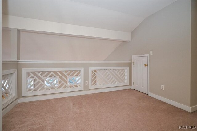 bonus room with light carpet and vaulted ceiling with beams