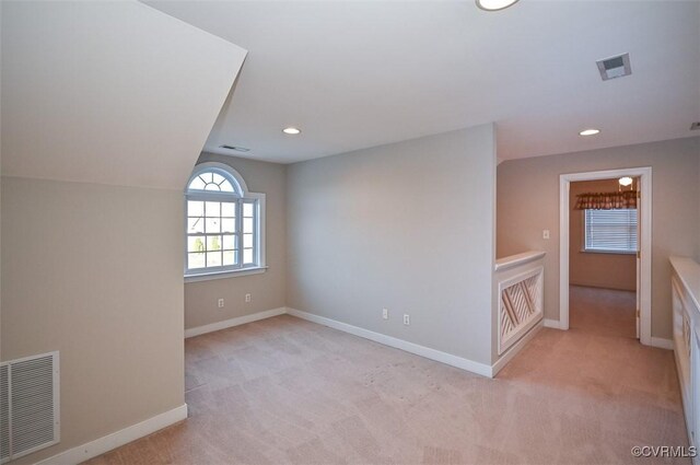 spare room with light carpet and lofted ceiling