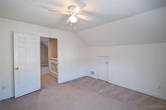 additional living space featuring ceiling fan, vaulted ceiling, and light colored carpet