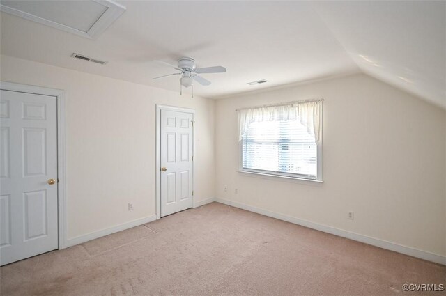 unfurnished bedroom featuring lofted ceiling, ceiling fan, and light colored carpet