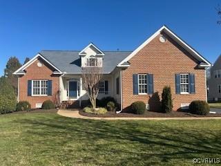 view of front of property featuring brick siding and a front yard