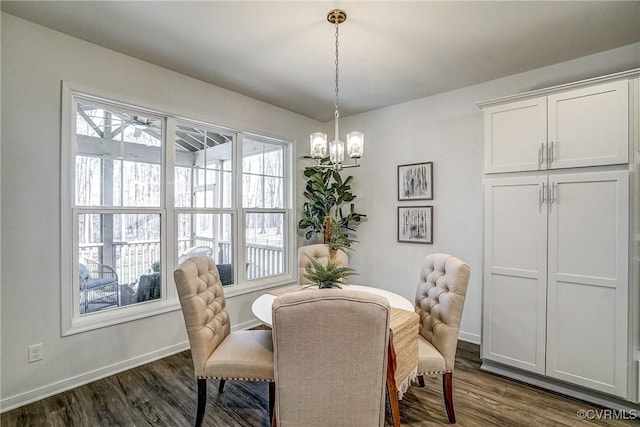 dining area with dark hardwood / wood-style flooring and a notable chandelier