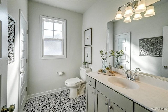 bathroom with toilet, vanity, and tile patterned flooring