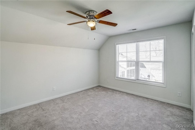 additional living space featuring light colored carpet, ceiling fan, and vaulted ceiling