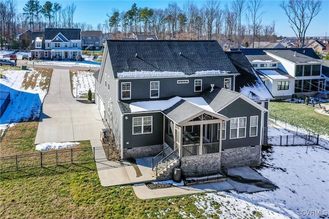 rear view of property featuring a lawn and a sunroom