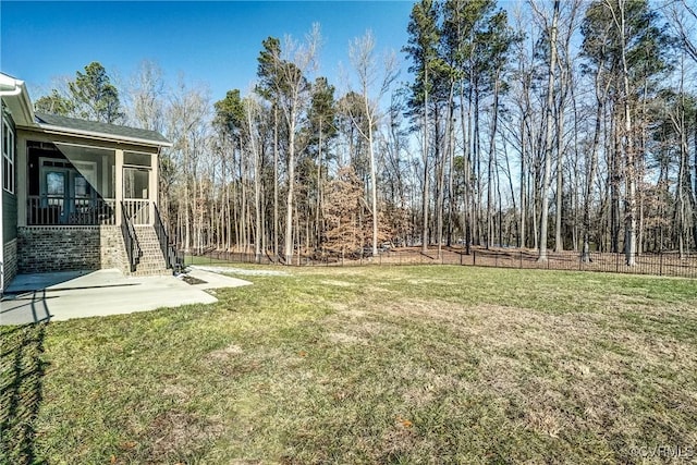 view of yard featuring a sunroom and a patio