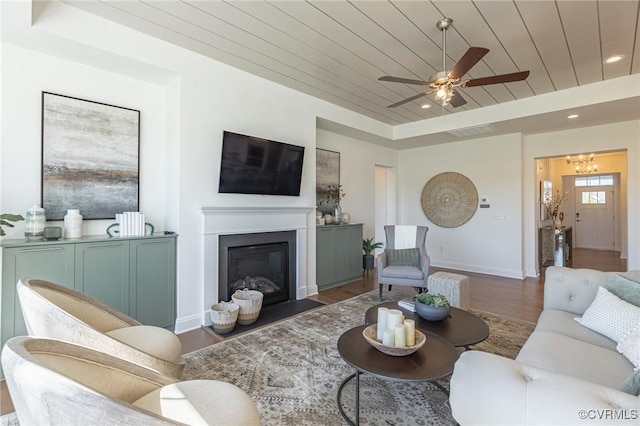 living room with dark hardwood / wood-style flooring, ceiling fan, and wooden ceiling