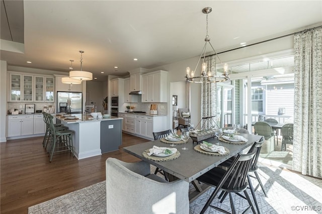 dining space with an inviting chandelier and dark hardwood / wood-style floors