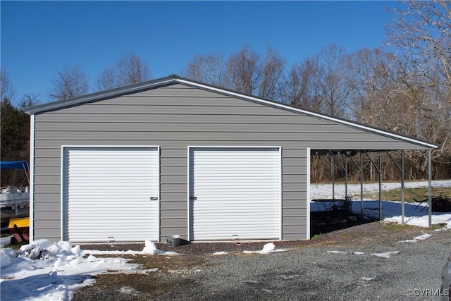 snow covered garage featuring a carport