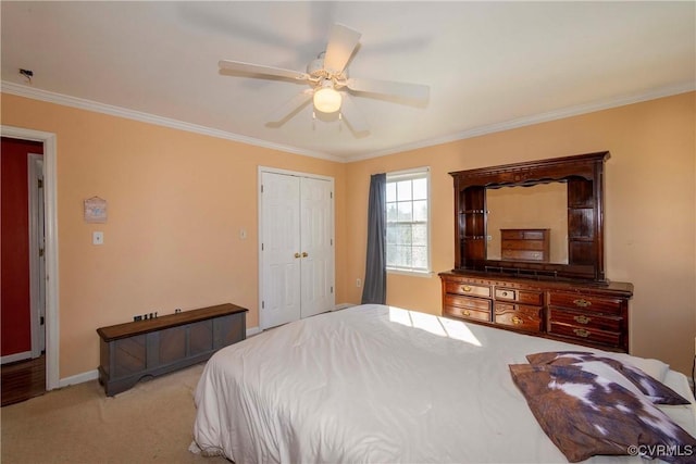 carpeted bedroom with a closet, ceiling fan, and ornamental molding