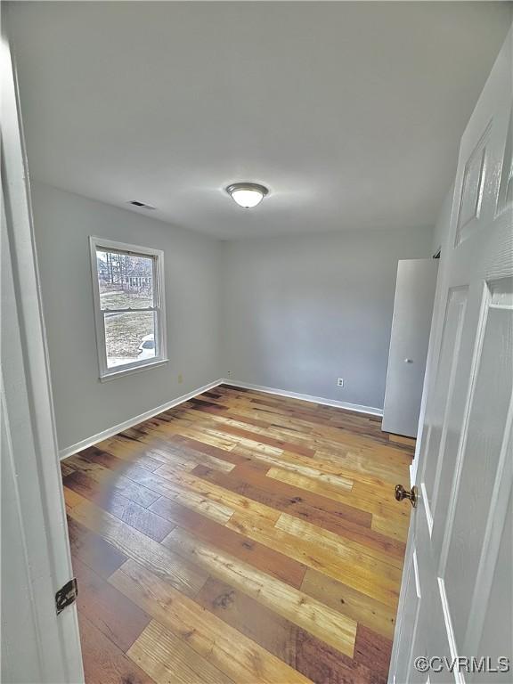 unfurnished room featuring hardwood / wood-style flooring