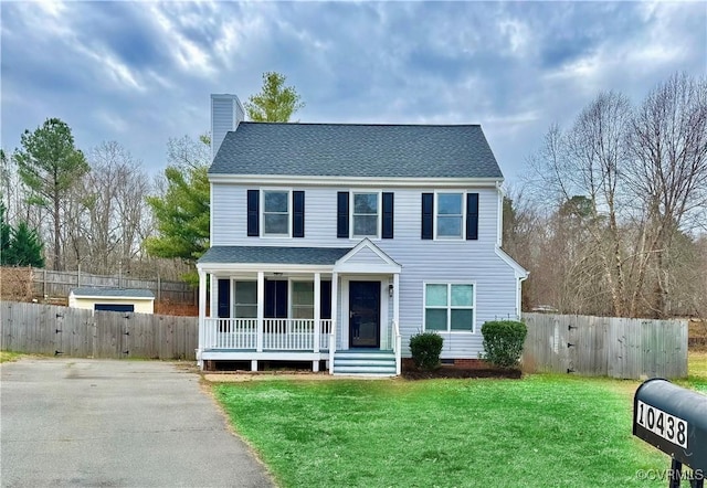 colonial home with a porch and a front yard