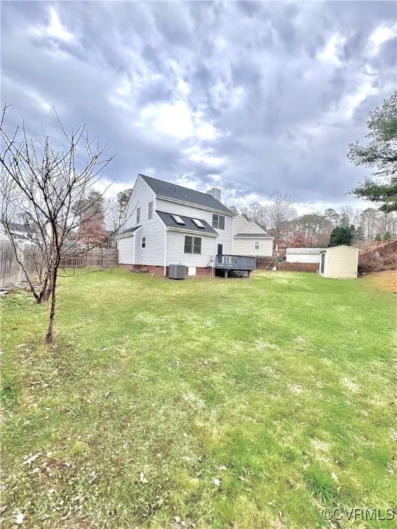 view of yard with a storage unit, central AC unit, and a wooden deck