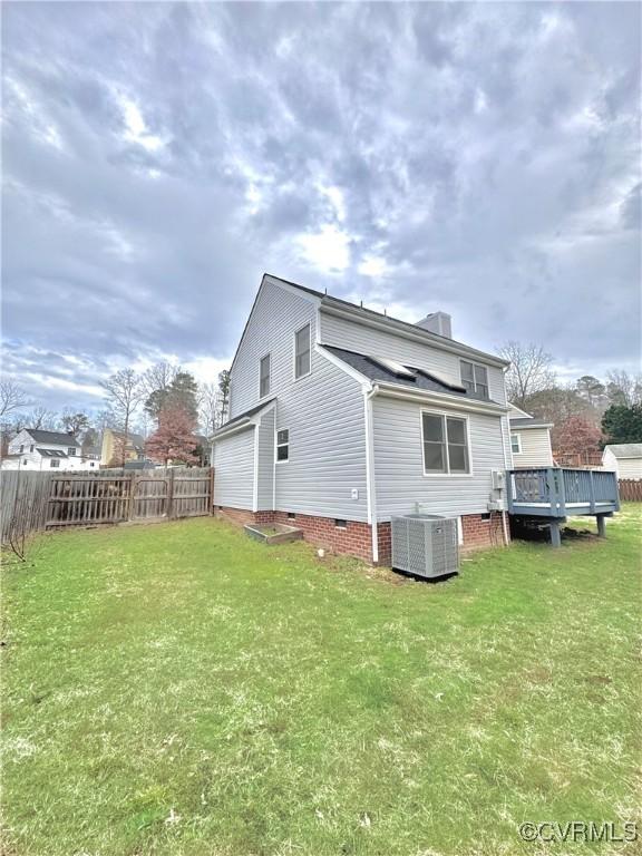 rear view of property featuring central AC, a deck, and a yard