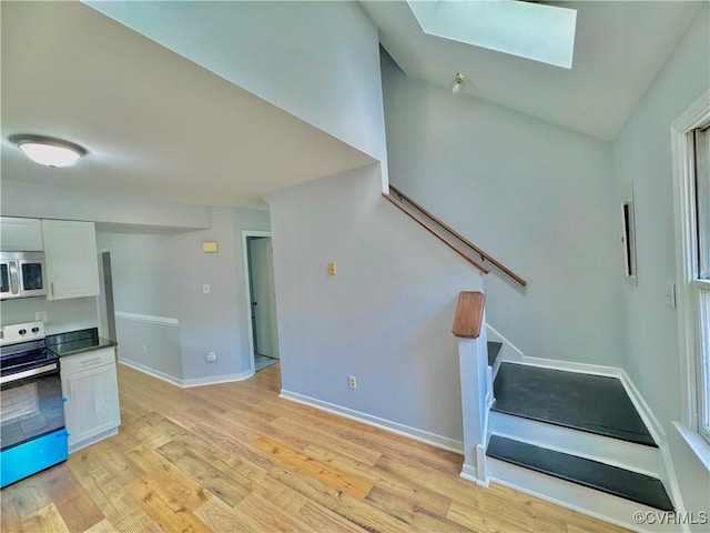 stairs with a skylight and wood-type flooring