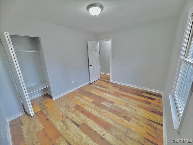 unfurnished bedroom featuring a closet and light wood-type flooring