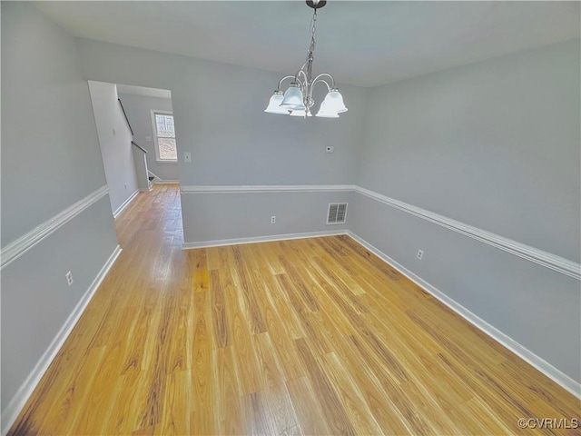 unfurnished dining area with light wood-type flooring and a chandelier