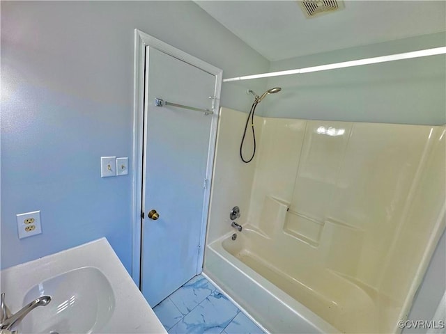 bathroom with washtub / shower combination and sink