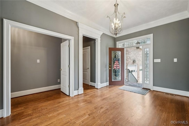 interior space with light hardwood / wood-style floors, a notable chandelier, and ornamental molding