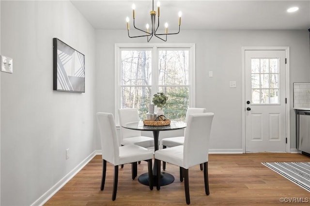 dining space featuring light hardwood / wood-style floors and a notable chandelier