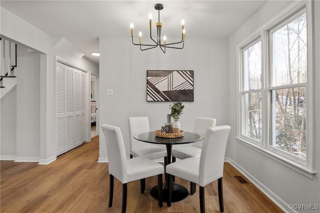 dining space featuring a notable chandelier, light wood-type flooring, and plenty of natural light