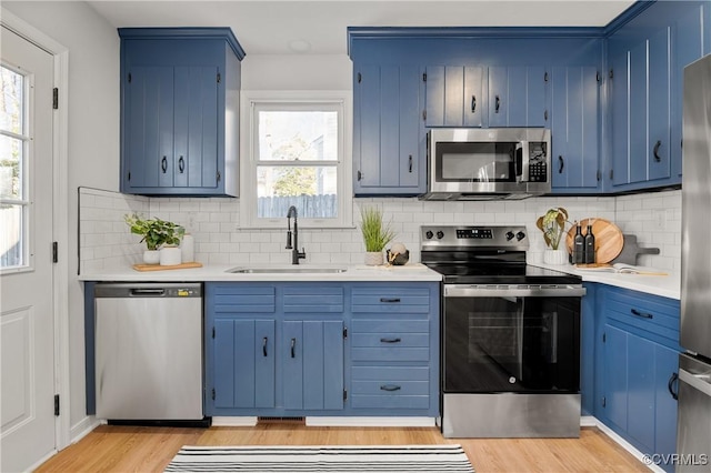 kitchen with sink, stainless steel appliances, and blue cabinetry