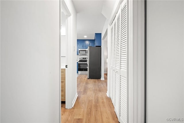 corridor with light hardwood / wood-style floors