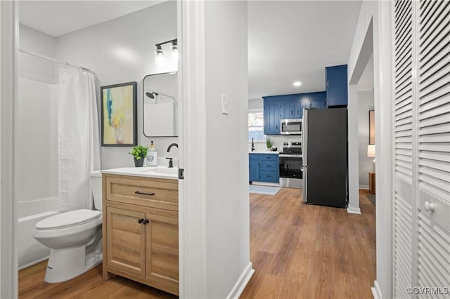 bathroom with toilet, wood-type flooring, tasteful backsplash, and vanity