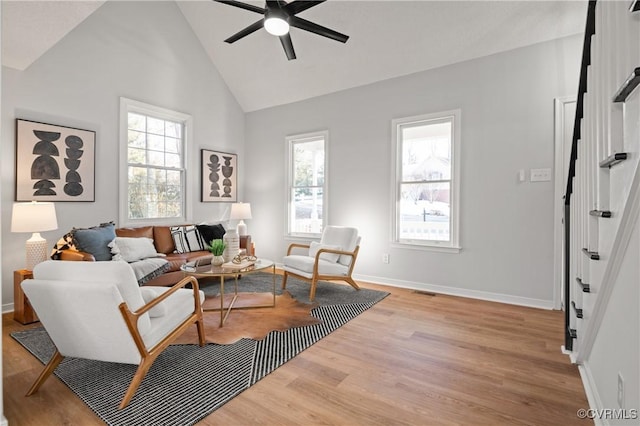 living room featuring high vaulted ceiling, light wood-type flooring, and ceiling fan