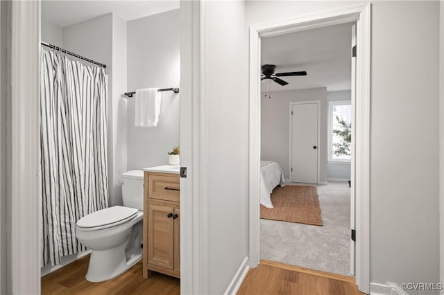 bathroom featuring toilet, vanity, ceiling fan, and hardwood / wood-style flooring