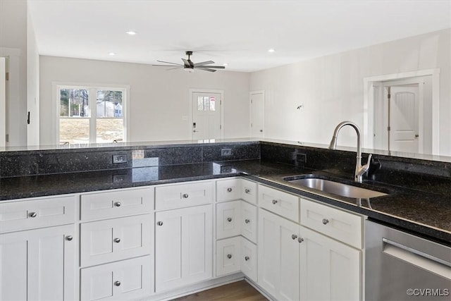 kitchen with white cabinets, dark stone counters, dishwasher, and sink