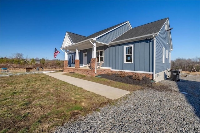 craftsman-style home featuring covered porch and a front lawn