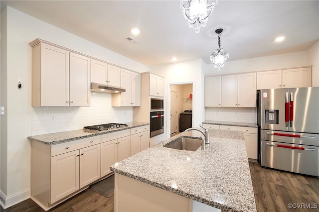 kitchen featuring stainless steel appliances, sink, an island with sink, a chandelier, and pendant lighting